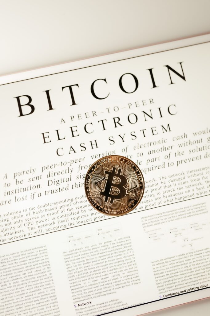 Close-up of a Bitcoin coin on the cryptocurrency's white paper showcasing digital cash concept.